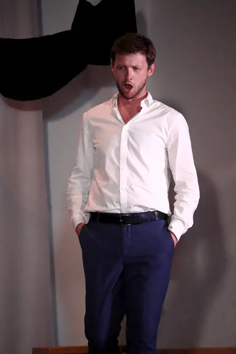 A singer in a white shirt on stage